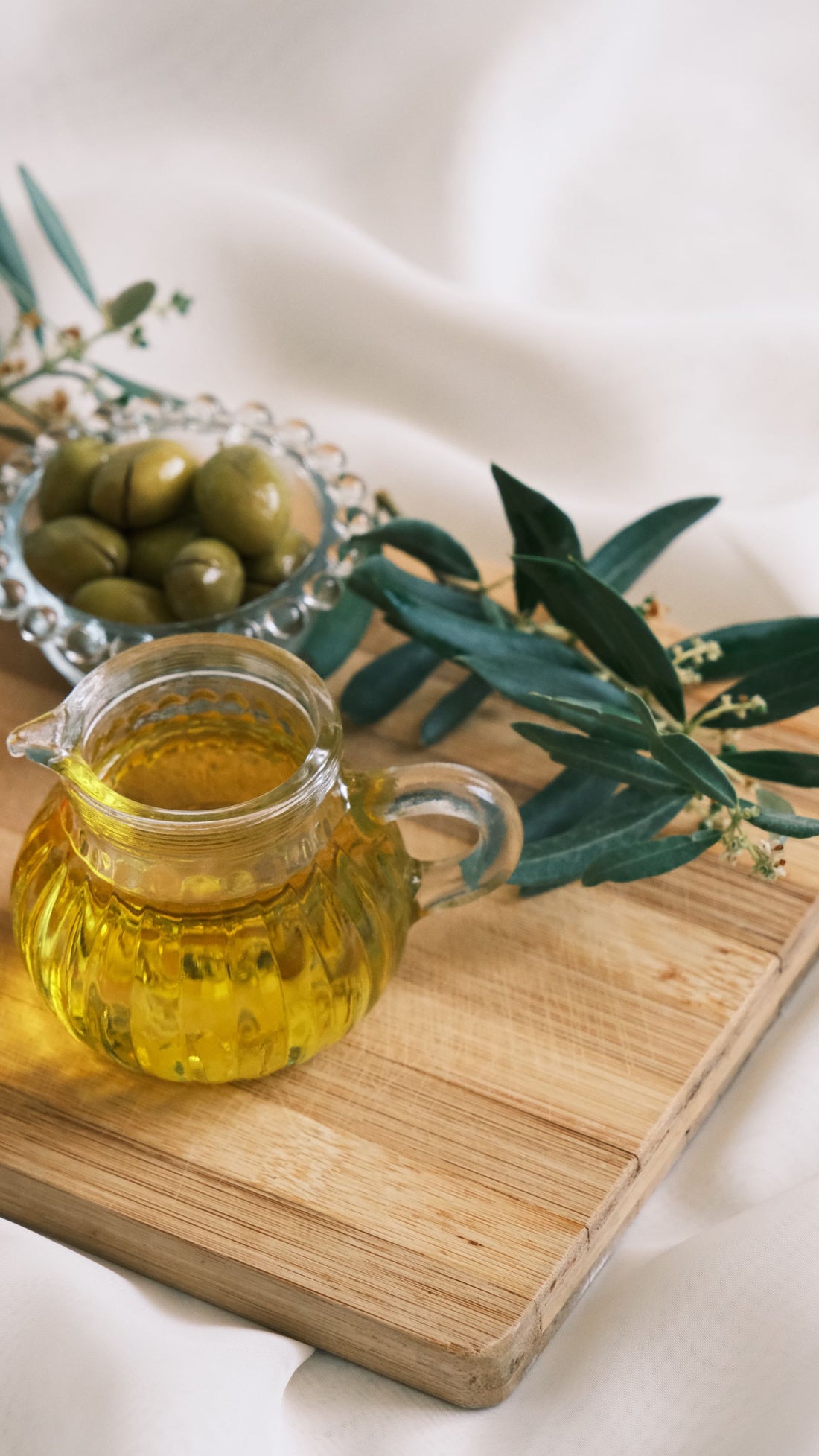 Olive oil and olives on a wooden board
