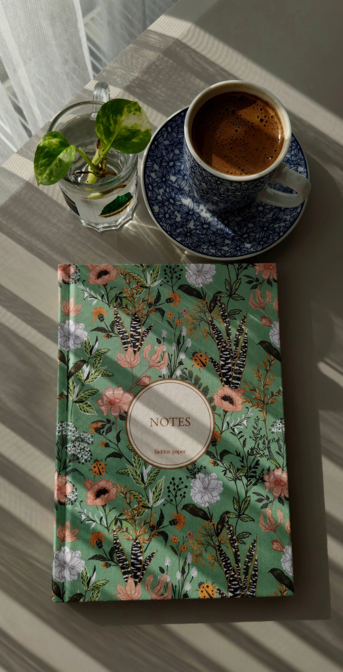 Floral notebook with coffee and a plant