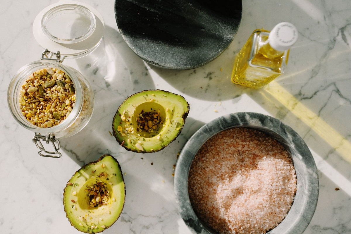 Avocado halves with a seed mix and breakfast ingredients