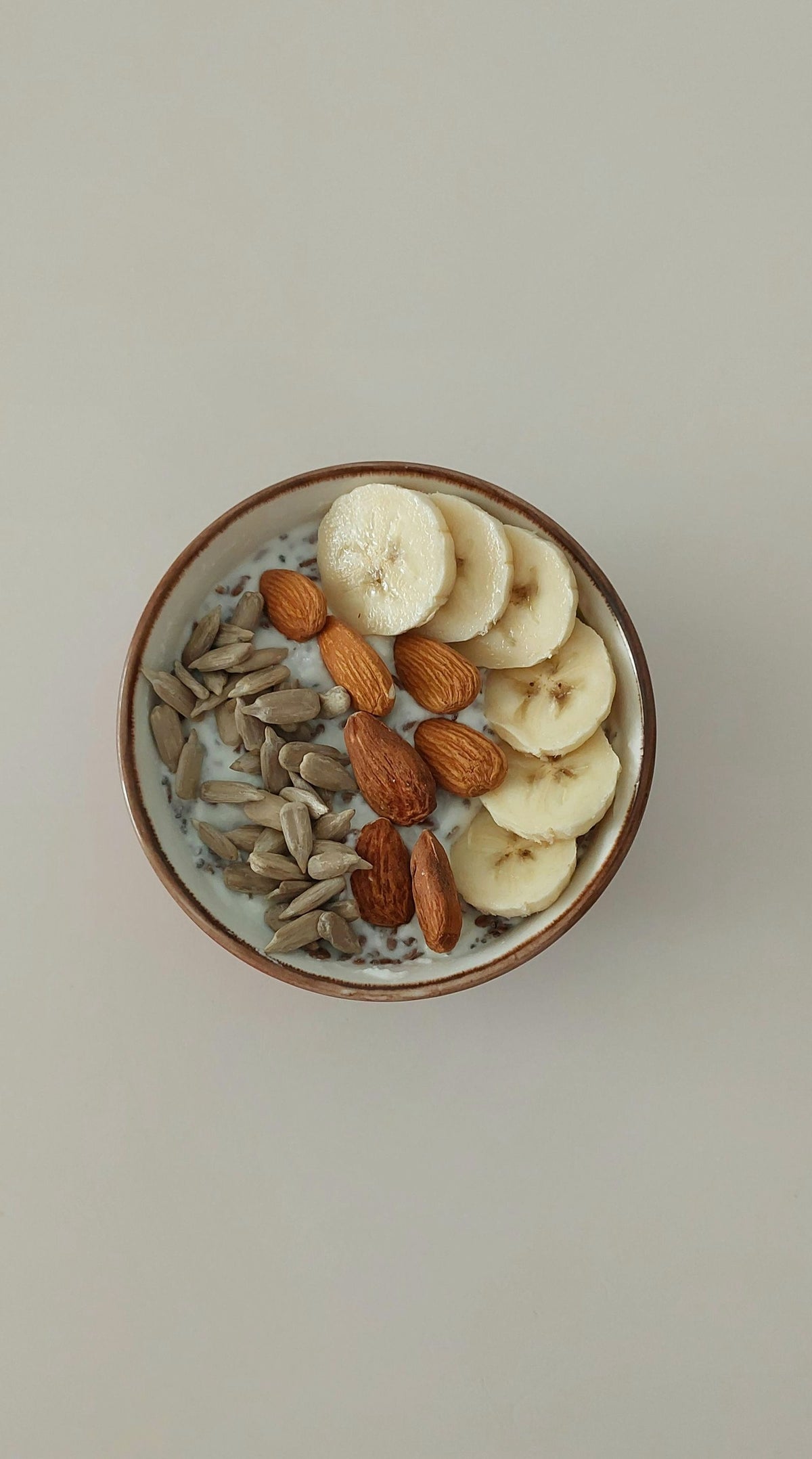 Breakfast bowl with banana, almonds and sunflower seeds