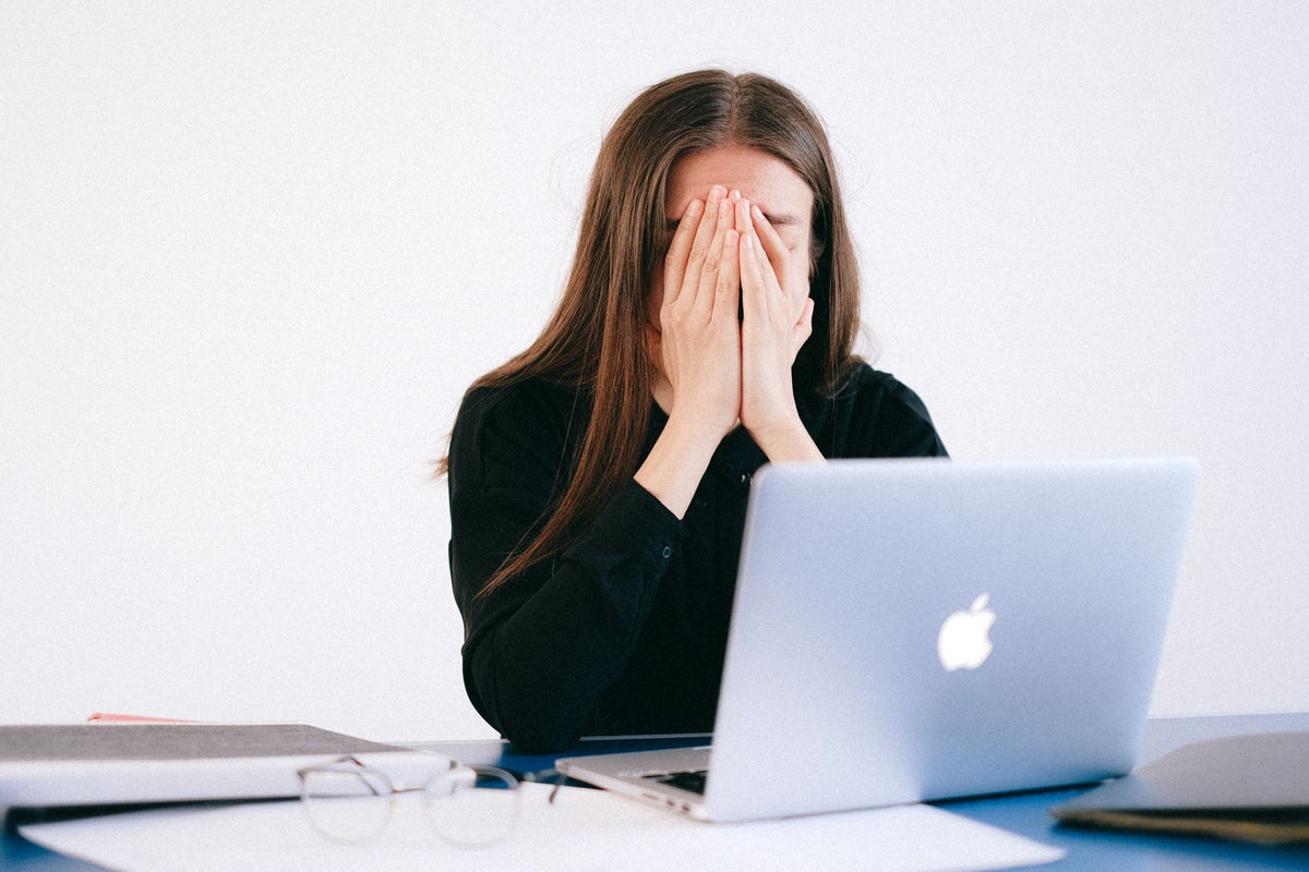 Woman feeling stressed while working on a laptop