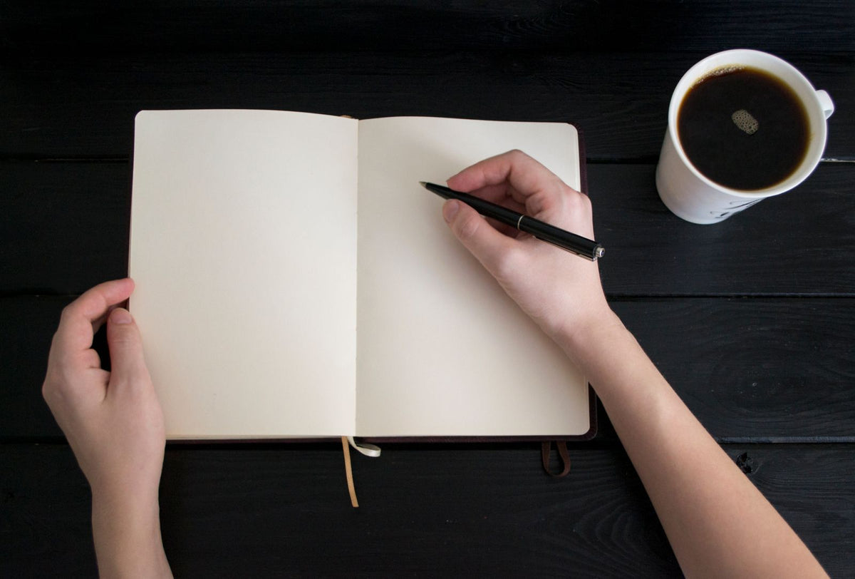 Notebook with a pen and a cup of coffee