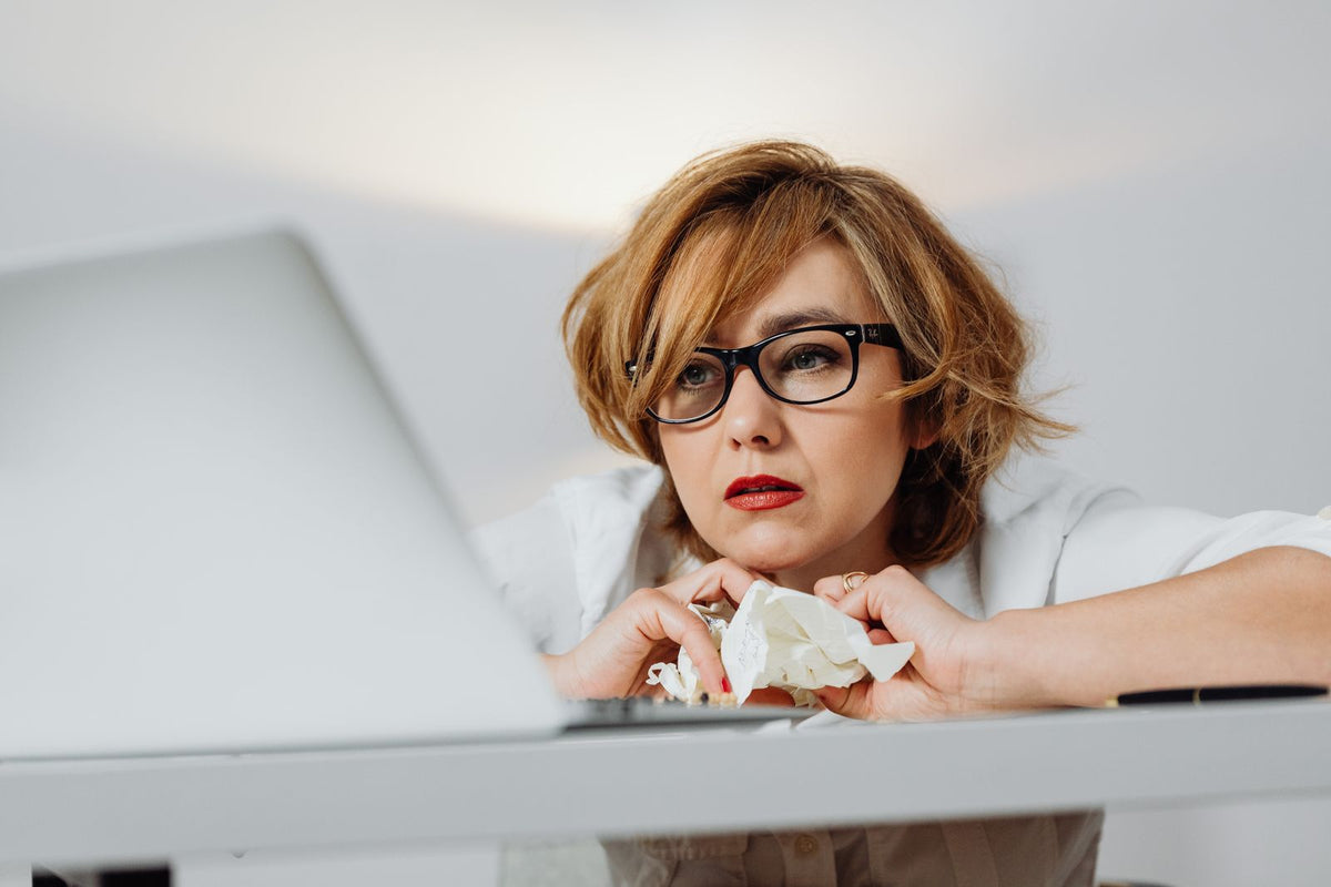 Stressed woman at a desk with a laptop