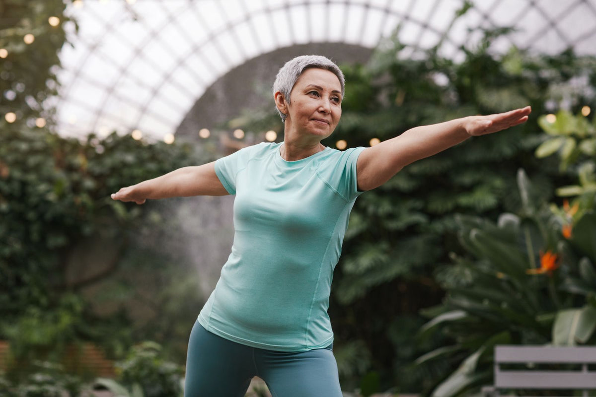 Woman in a yoga pose in a botanical garden