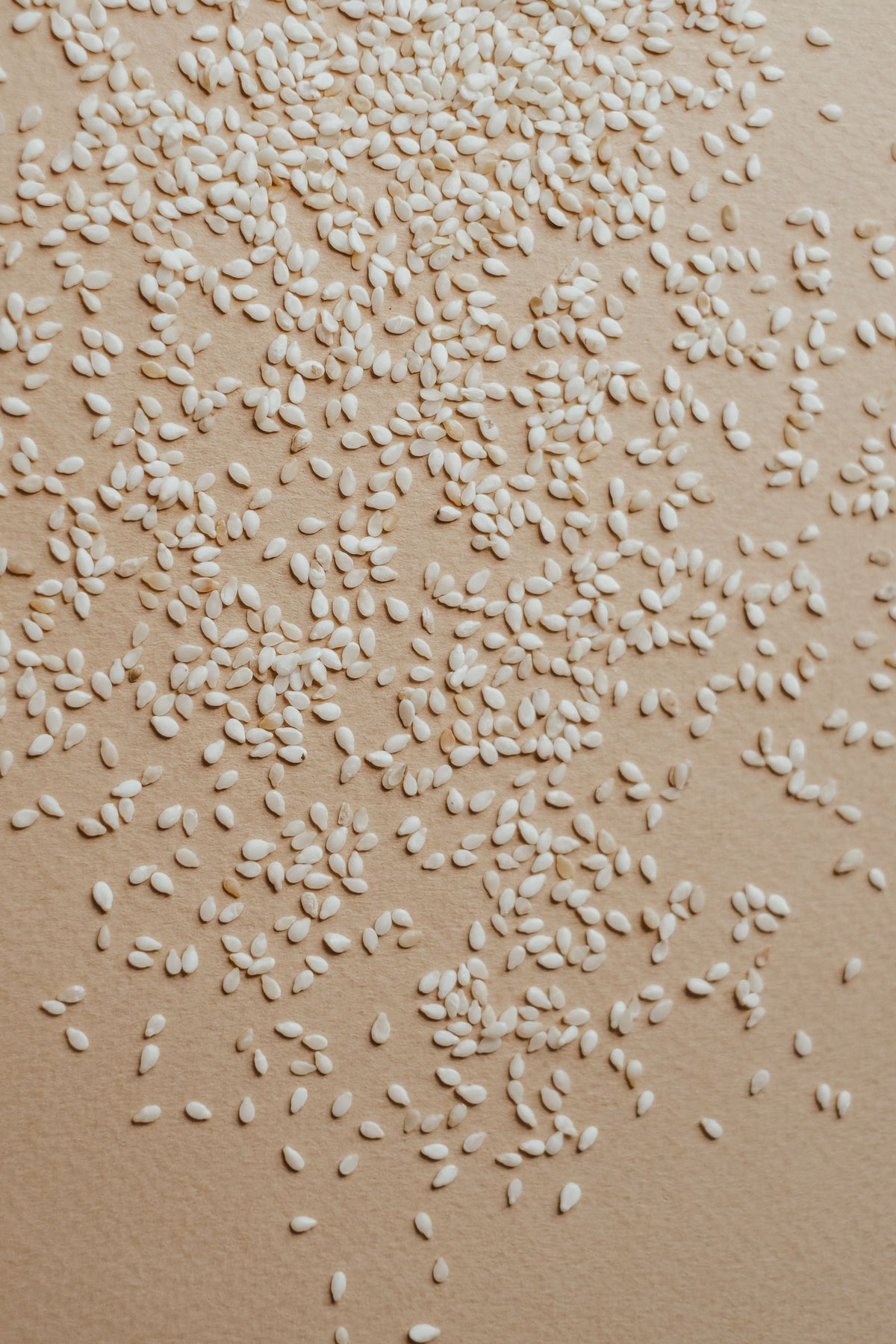 Raw sesame seeds scattered on a surface