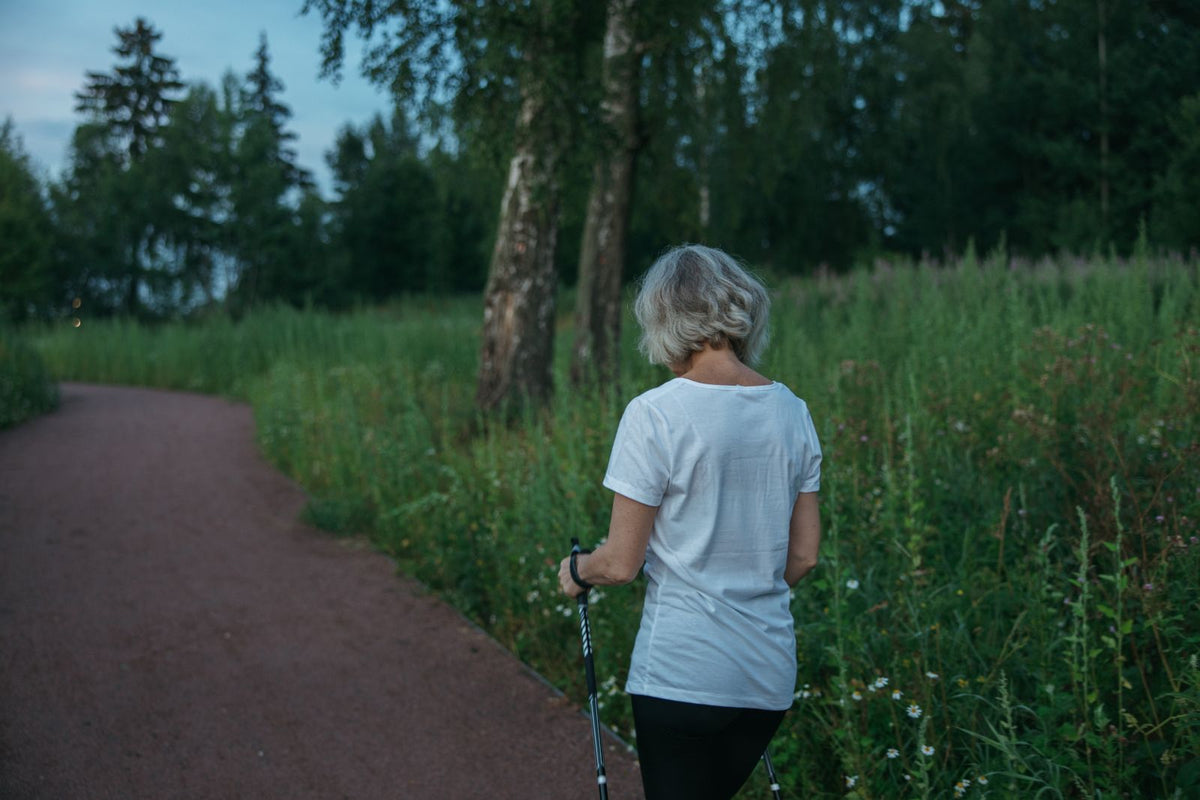 Woman Nordic walking on a park trail