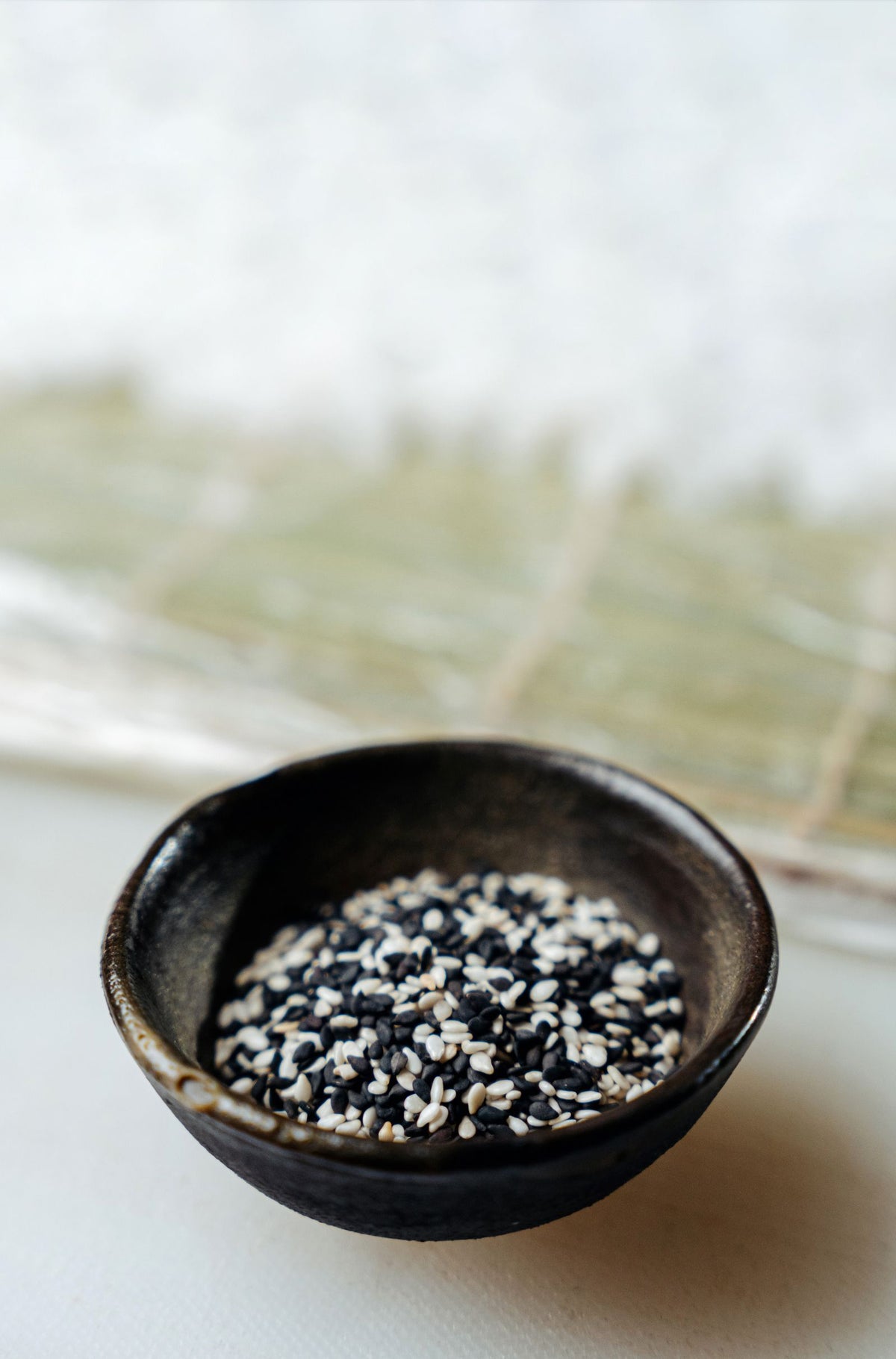 Black and white sesame seeds in a ceramic bowl